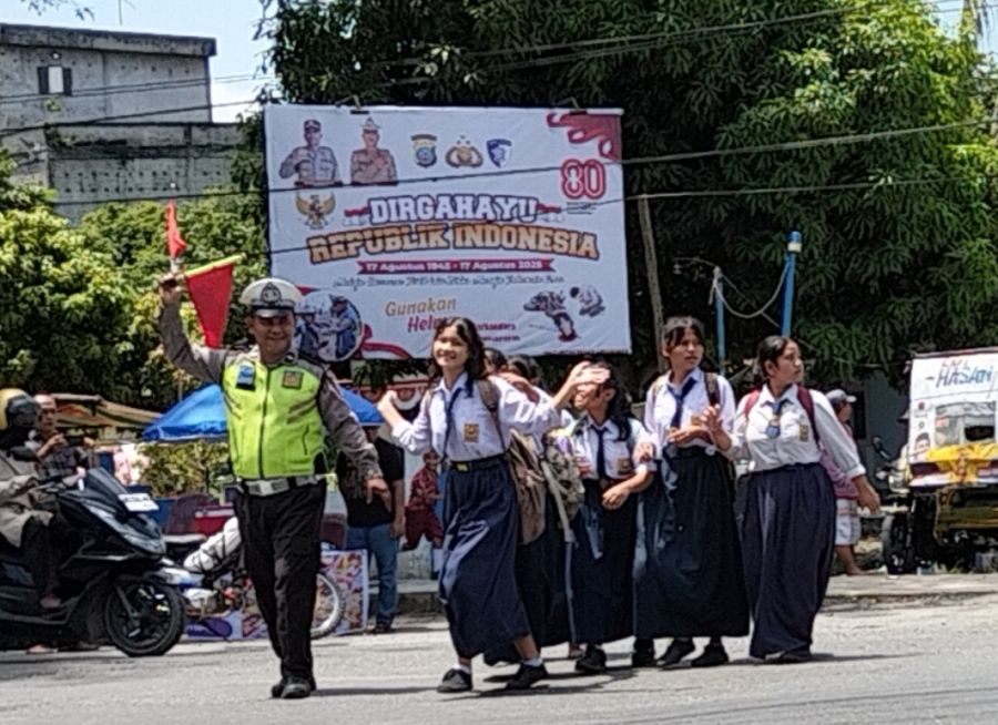 Unit Lantas Polsek Kualuh Hulu Lakukan Rutinitas Menyeberangkan Anak Sekolah di Jalinsum Aek kanopan